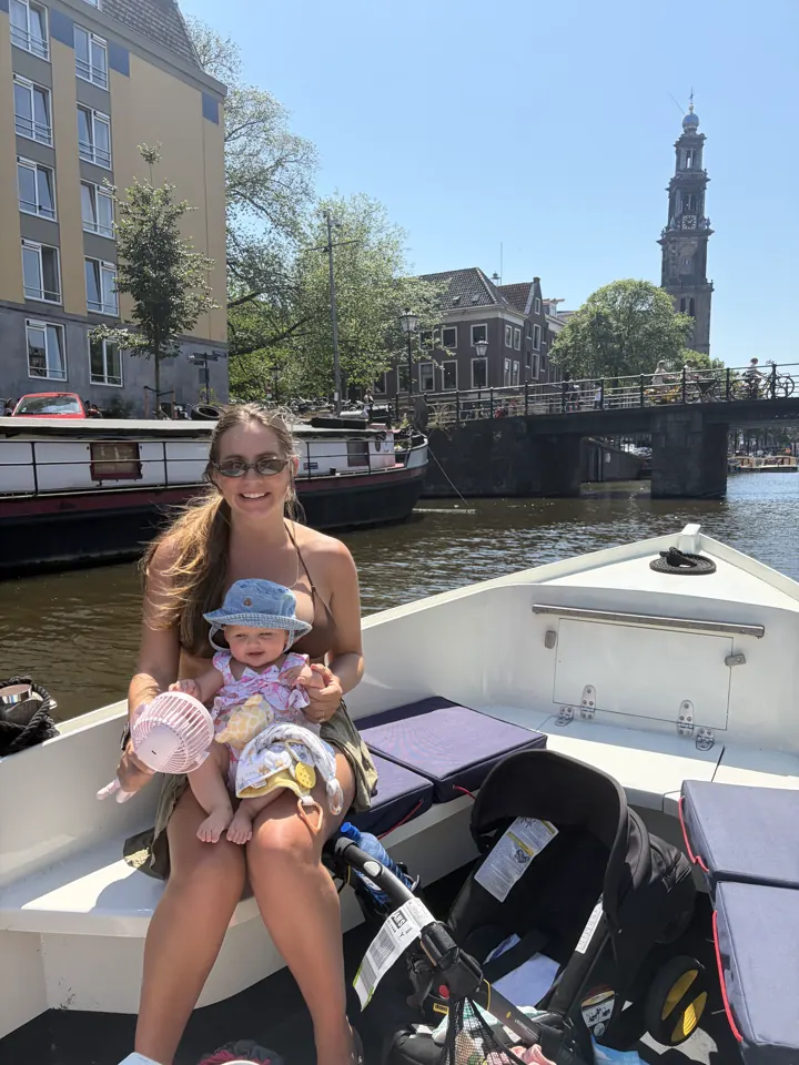 Angela holding Andi on a small boat on an Amsterdam canal